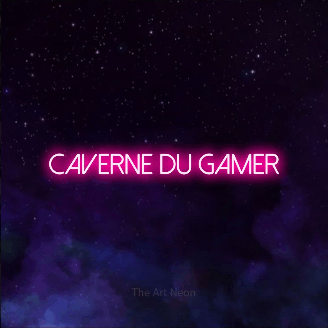 “Caverne du gamer” LED neon sign in hot pink, with thin sans-serif lettering, shown against a purple galaxy backdrop.