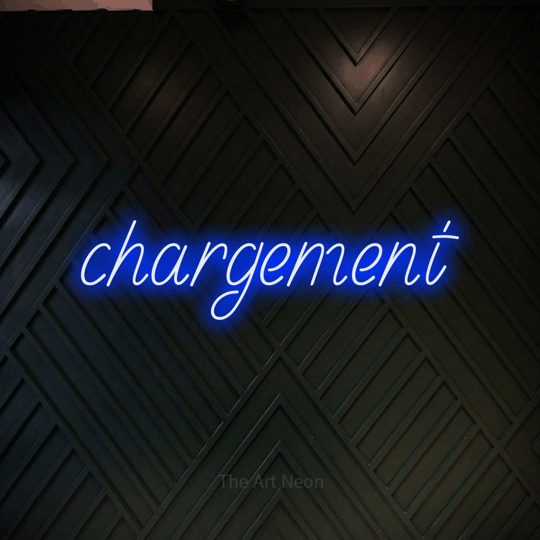 “Chargement” LED neon sign in blue, with slanted handwritten lettering, shown against a black chevron-patterned wood wall.