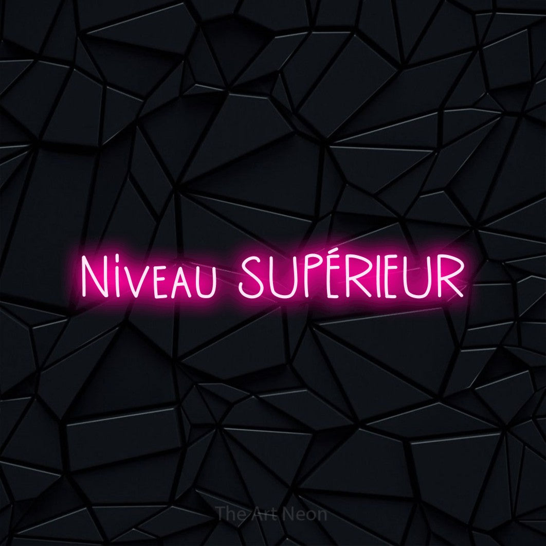 “Niveau supérieur” LED neon sign in hot pink, with narrow hand-drawn lettering, shown against a black polygonal surface.