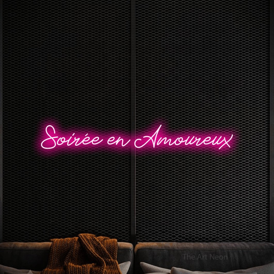 “Soirée en amoureux” LED neon sign in hot pink, with cursive lettering, shown against a modern dark-toned seating area.