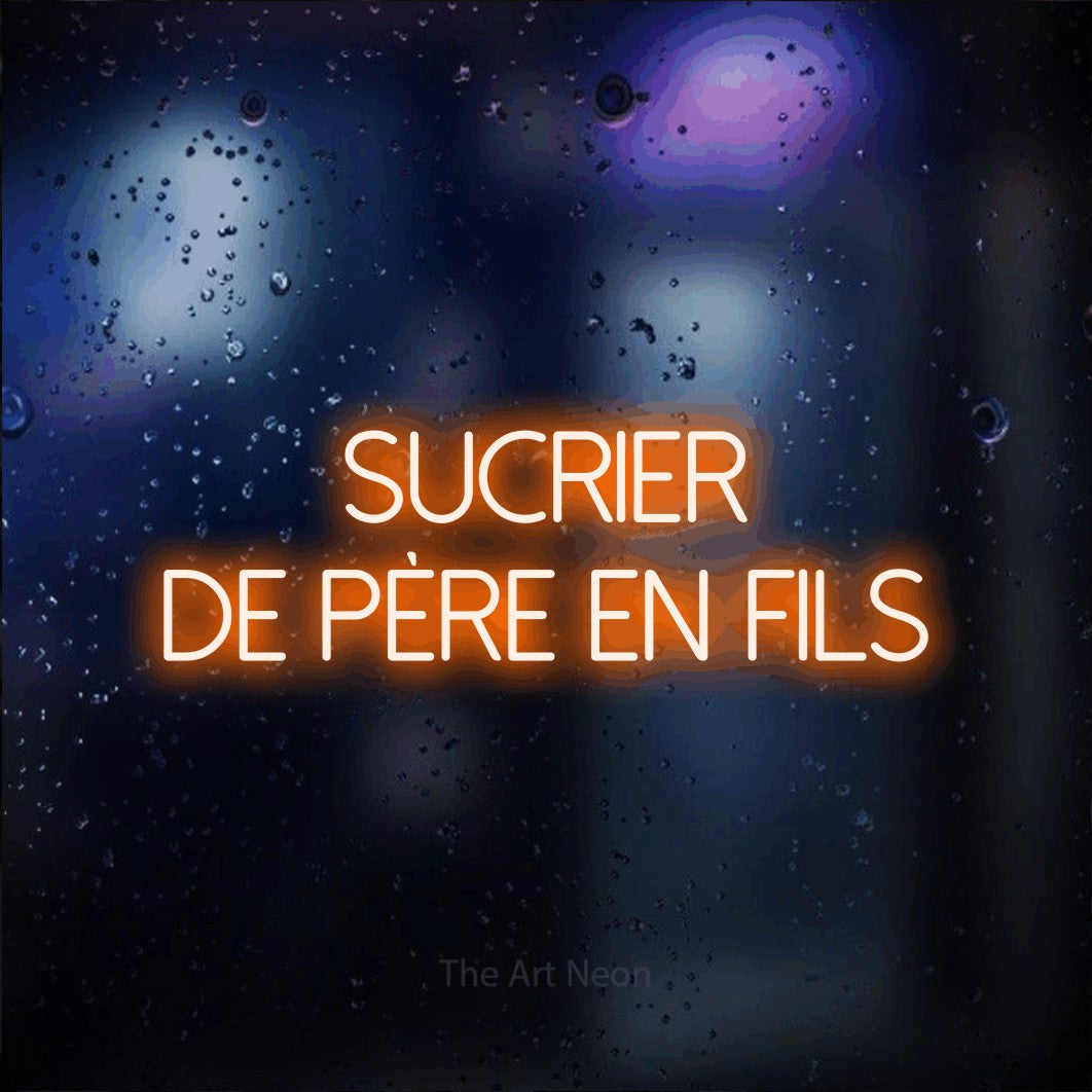 “Sucrier de père en fils” LED neon sign in orange, with thin sans-serif lettering across 2 lines, shown against glass with blue and purple reflections.
