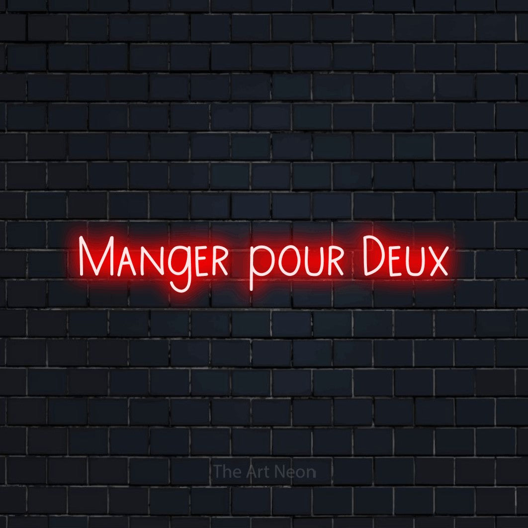 Néon LED « Manger pour deux » en rouge, en lettres étroites dessinées à la main, mis en scène sur un mur de briques bleu marine foncé, pour une fête prénatale.