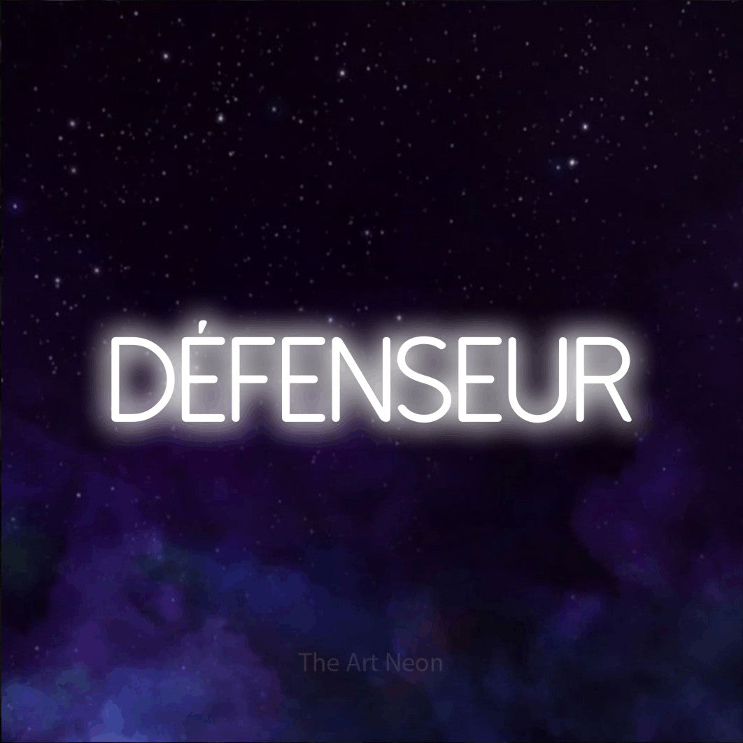 “Défenseur” LED neon sign in cool white, with thin sans-serif lettering, shown against a purple galaxy backdrop.