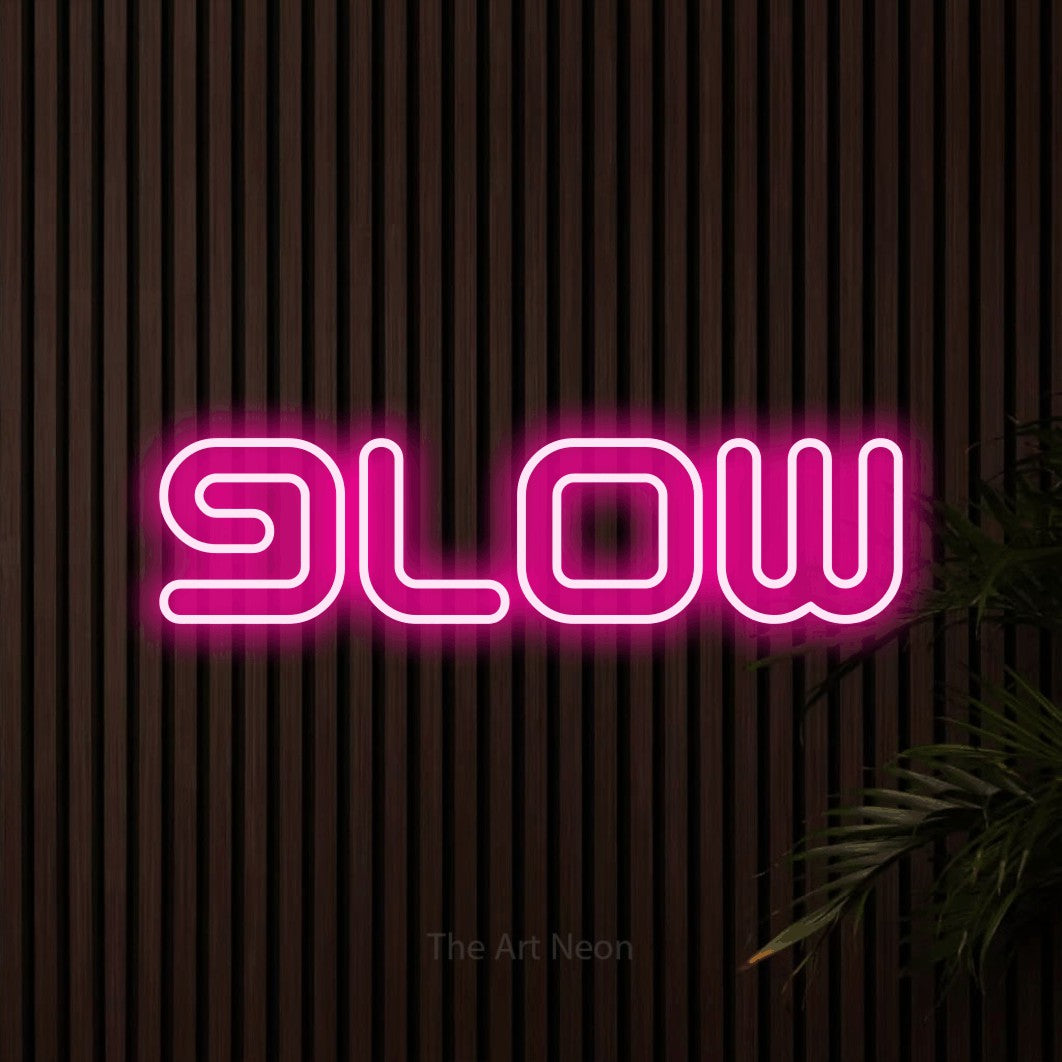 “Glow” LED neon sign in hot pink, with futuristic double-line lettering, shown against dark wooden wall slats.