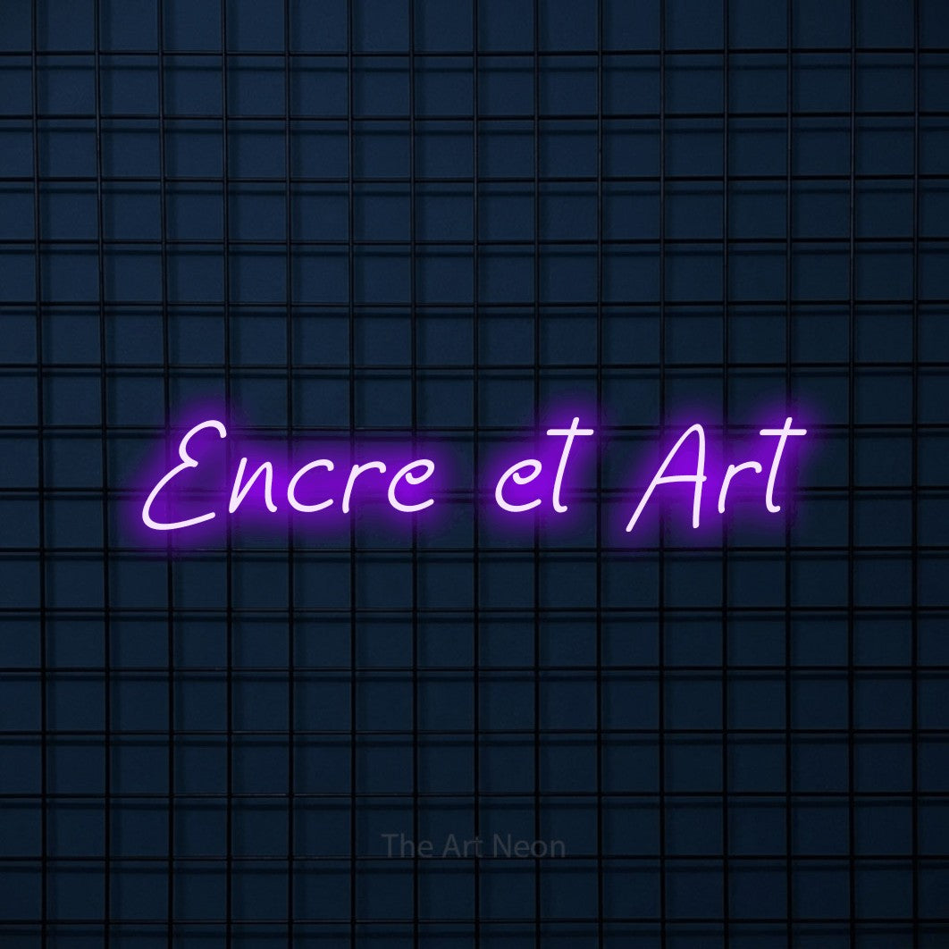 “Encre et art” LED neon sign in purple, with slanted handwritten lettering, shown against a dark blue grid.