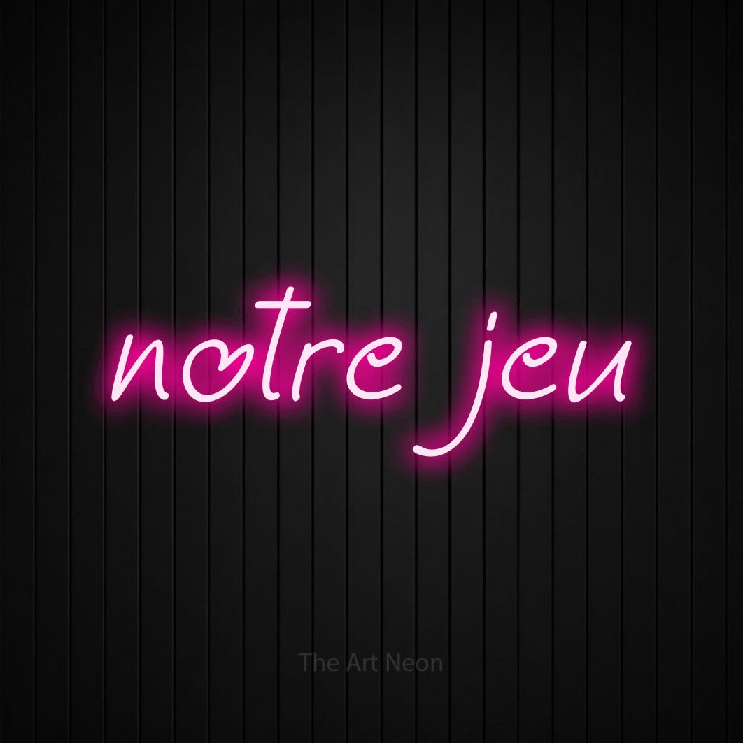 “Notre jeu” LED neon sign in hot pink, with slanted handwritten lettering, shown against black vertical wall slats.