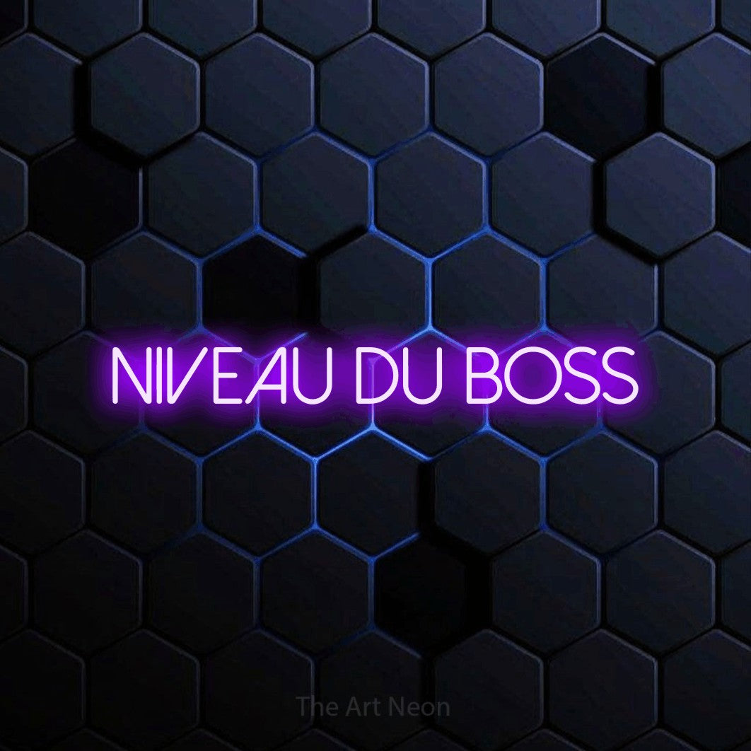 “Niveau du boss” LED neon sign in purple, with thin sans-serif lettering, shown against a dark blue honeycomb pattern.