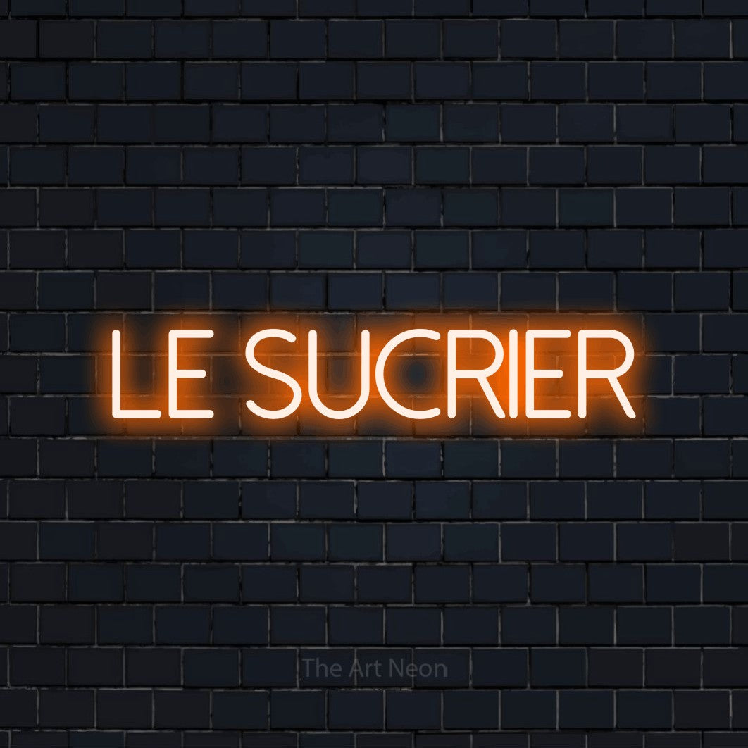 Lettrage en néon LED « Le sucrier » en orange, en lettres fines sans empattement, présenté sur un mur de briques bleu marine foncé, pour une cabane à sucre.