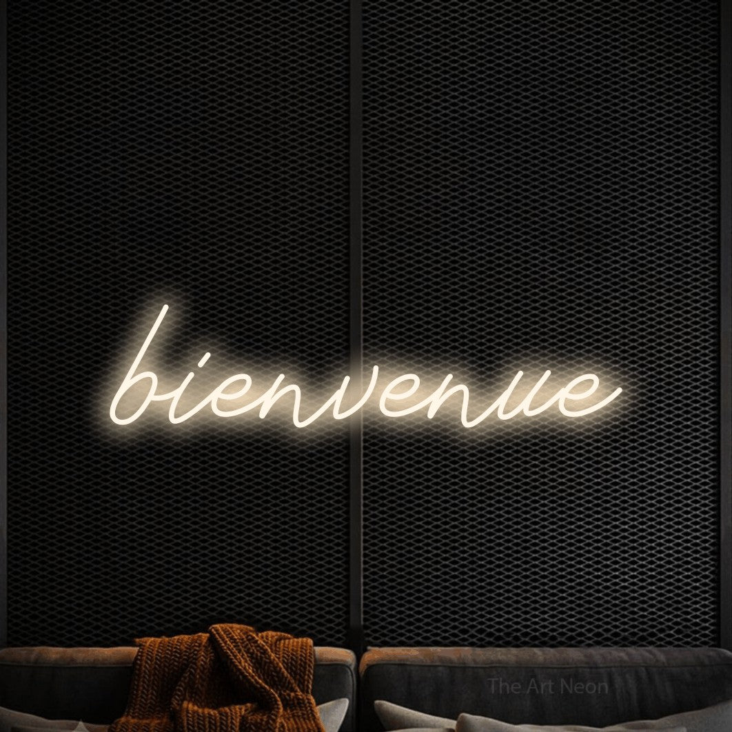 “Bienvenue” LED neon sign in warm white, with cursive lettering, shown against a modern dark-toned seating area.