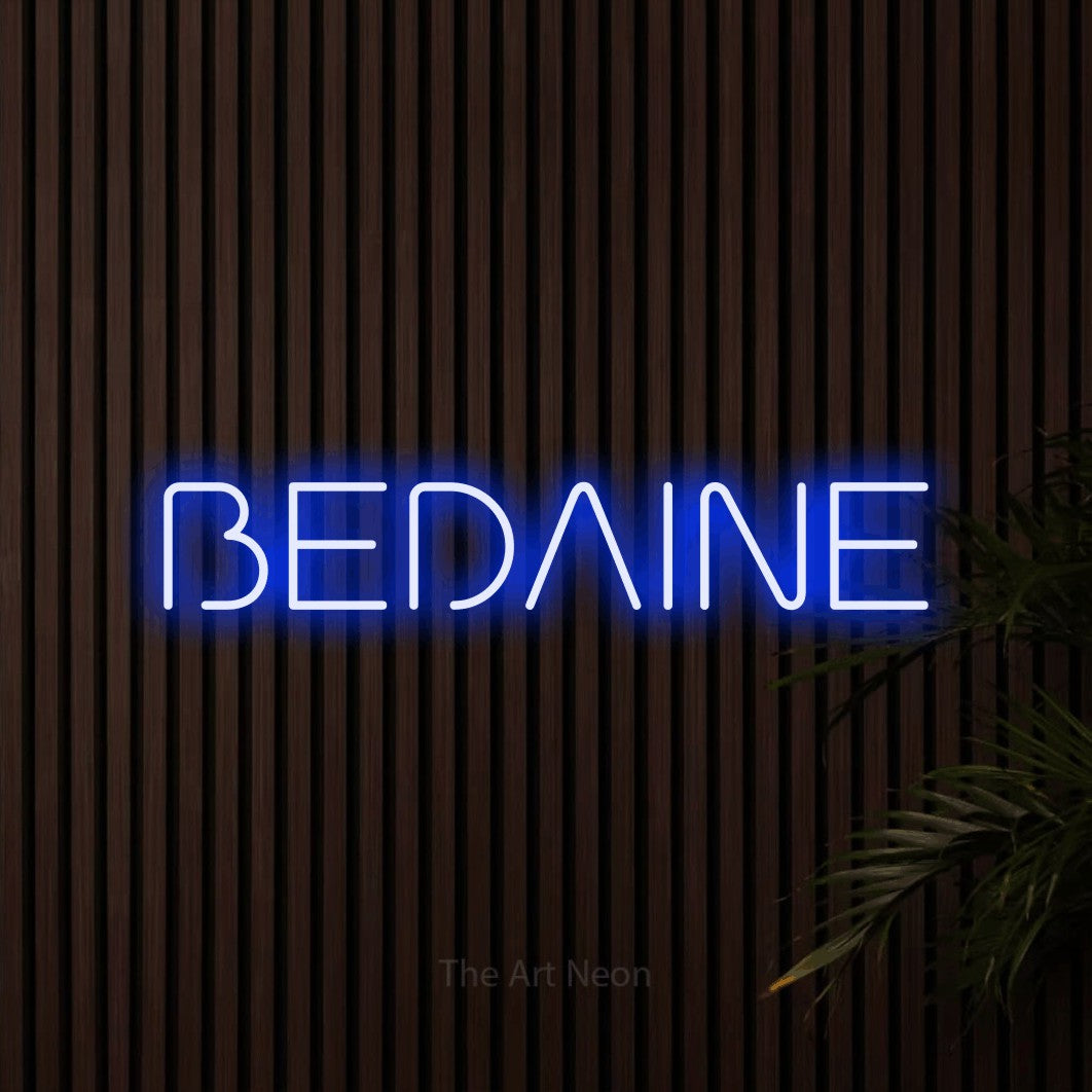 “Bedaine” LED neon sign in blue, with stylised geometric lettering, shown against dark wooden wall slats.