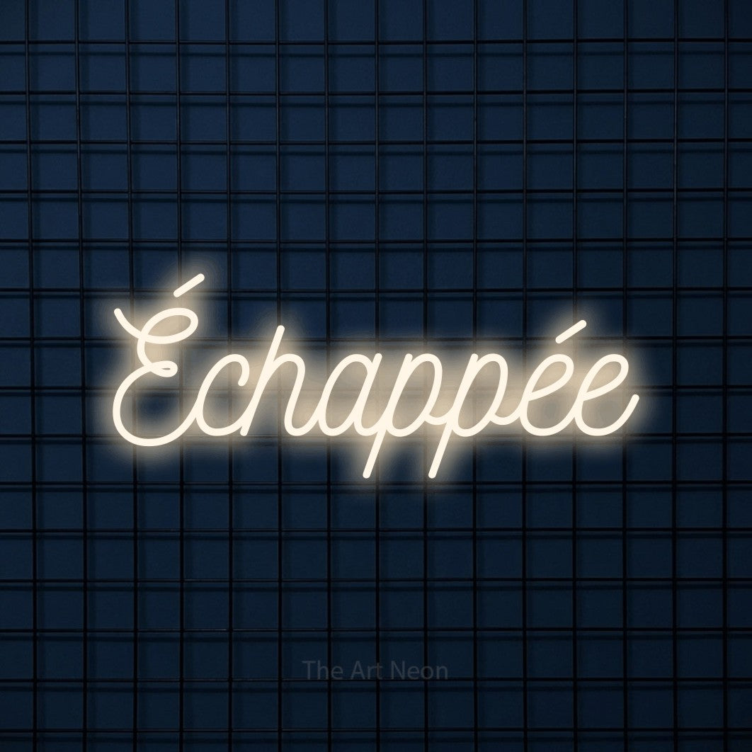 “Échappée” LED neon sign in warm white, with ornate cursive lettering, shown against a dark blue grid.