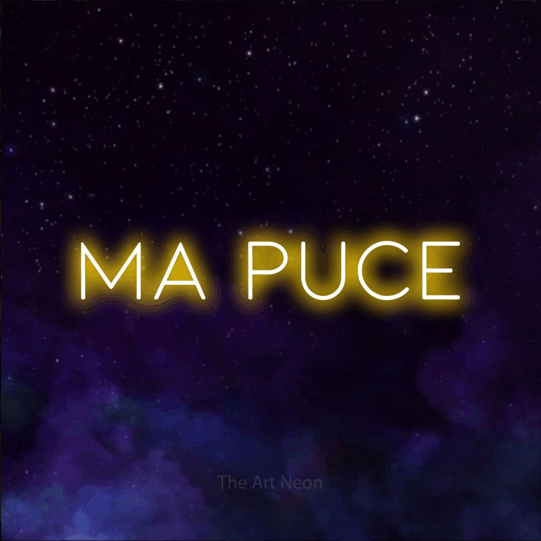 “Ma puce” LED neon sign in yellow, with thin, widely spaced lettering, shown against a purple galaxy backdrop.
