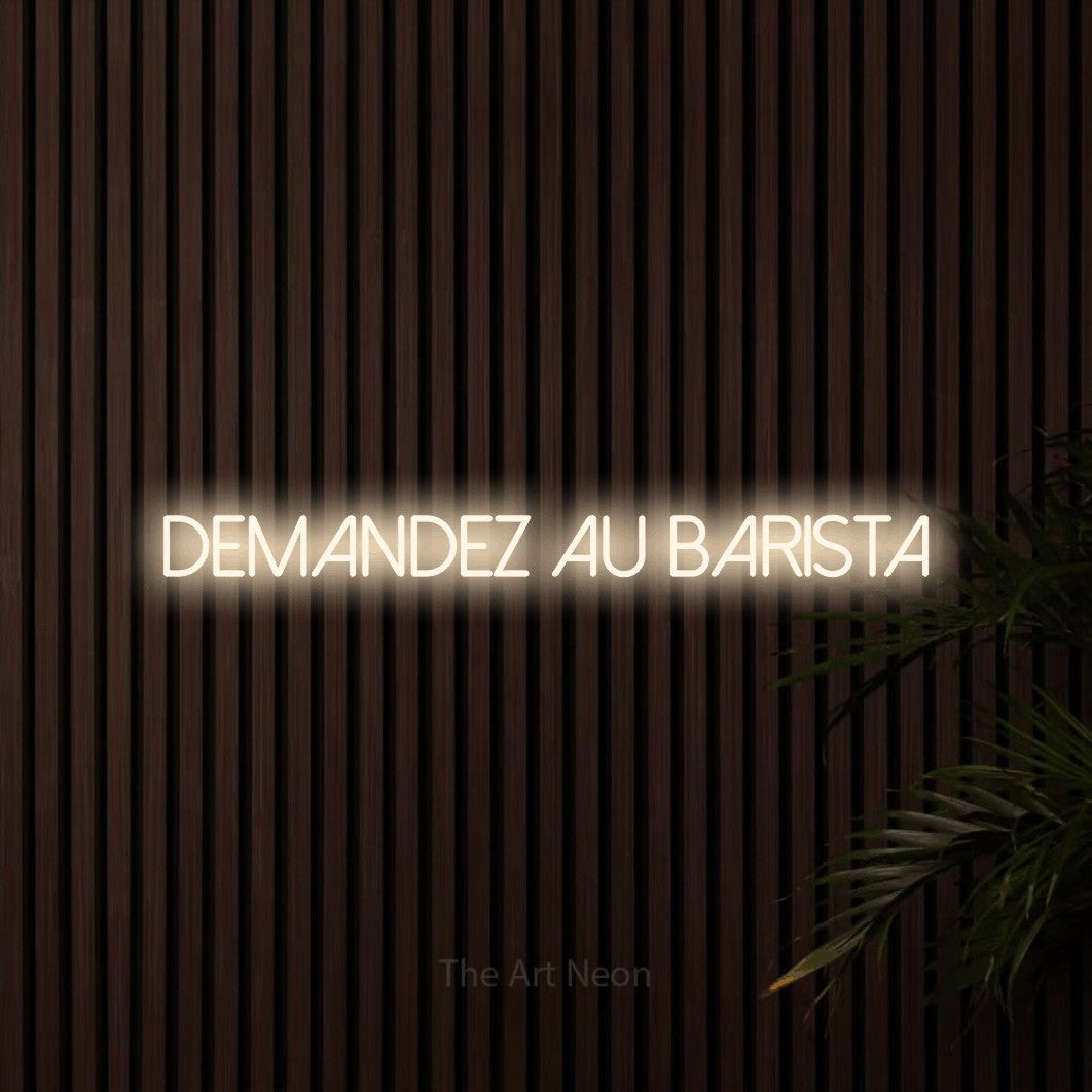 “Demandez au barista” LED neon sign in warm white, with thin sans-serif lettering, shown against dark wooden wall slats.