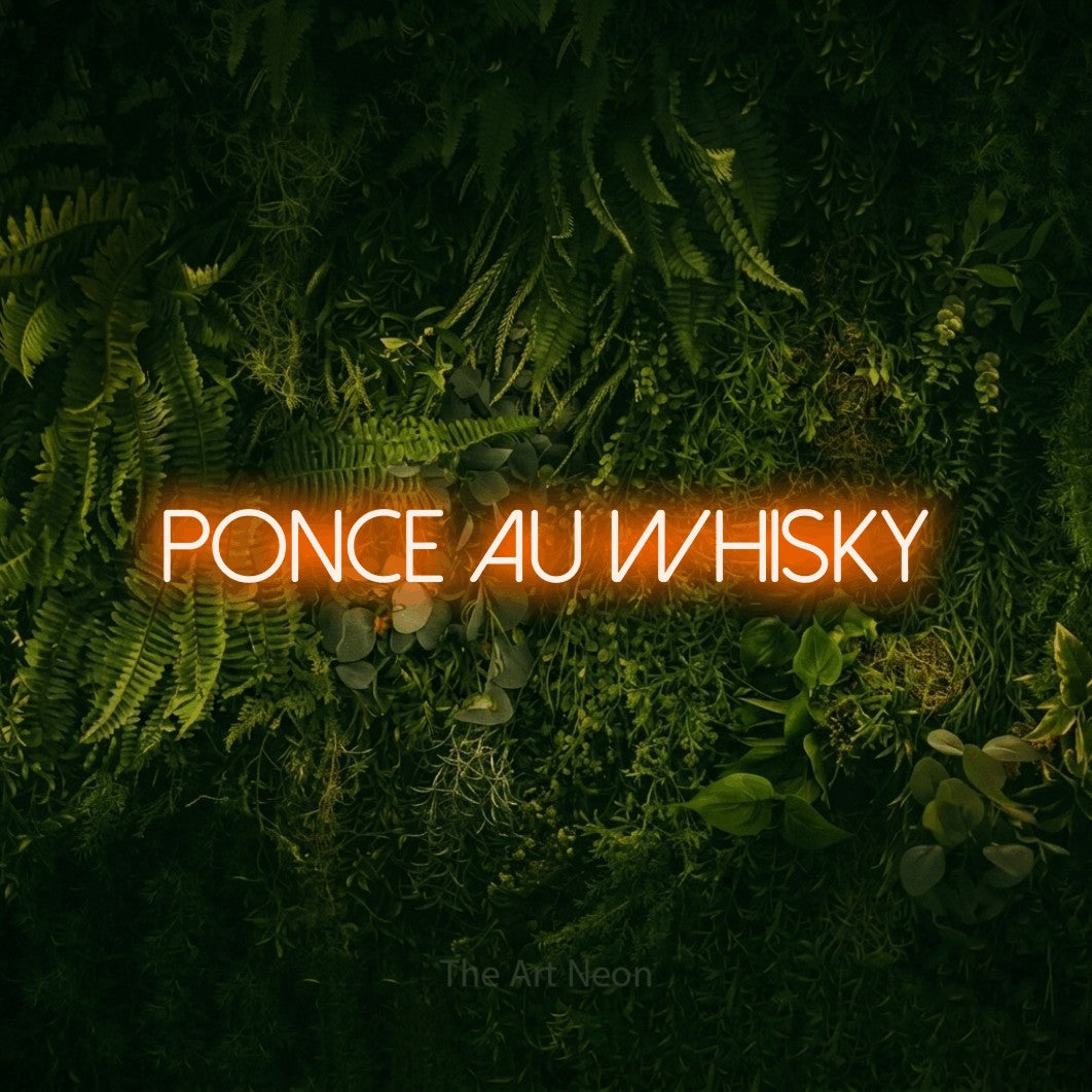 “Ponce au whisky” LED neon sign in orange, with thin sans-serif lettering, shown against a dark moss and forest backdrop.