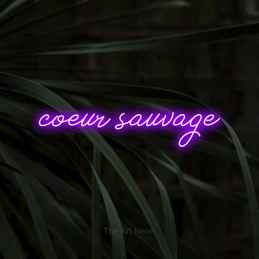 Enseigne néon LED « Cœur sauvage » en violet, en lettrage cursif, présentée sur un feuillage sombre en gros plan, pour un décor de plein air canadien.