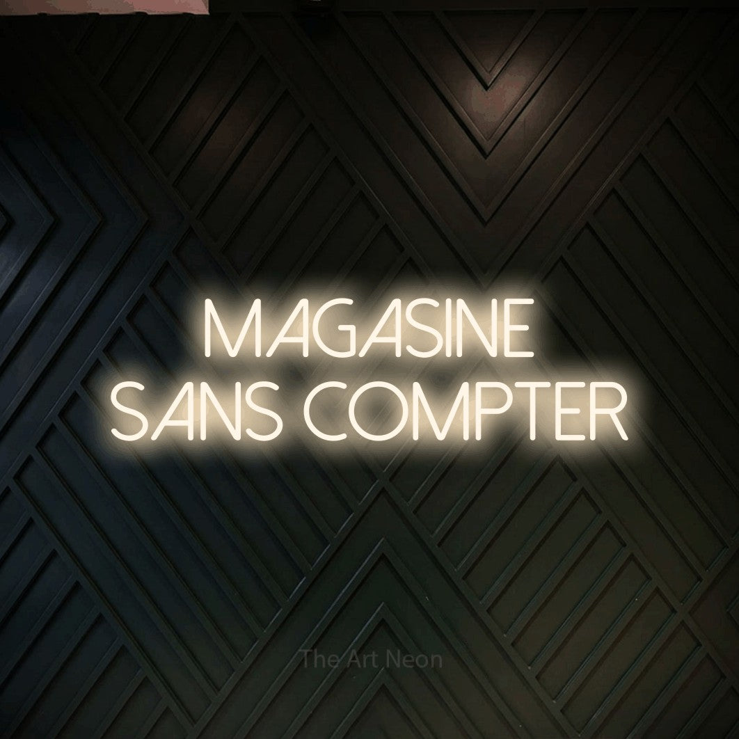 “Magasine sans compter” LED neon sign in warm white, with thin sans-serif lettering across 2 lines, shown against a black chevron-patterned wood wall.