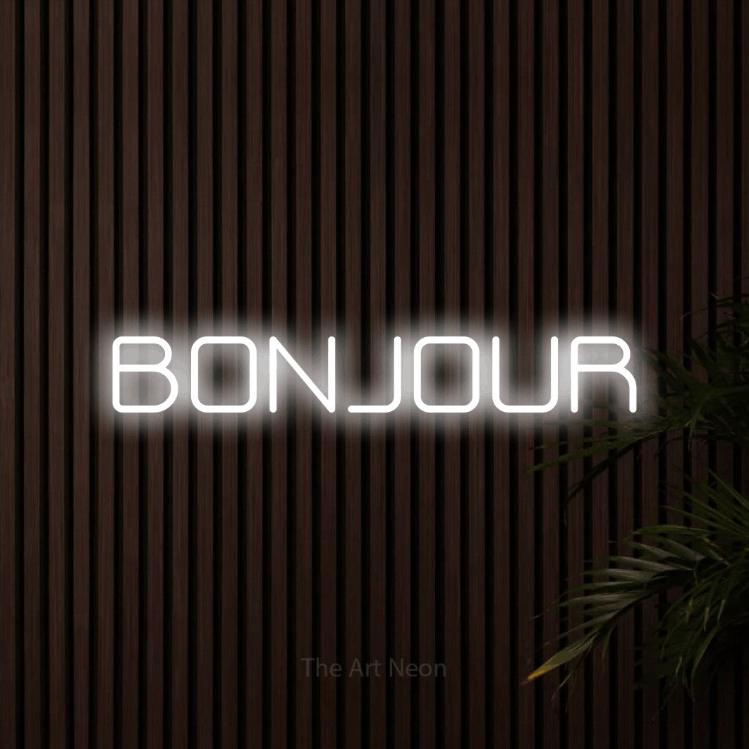 “Bonjour” LED neon sign in cool white, with rounded geometric lettering, shown against dark wooden wall slats.