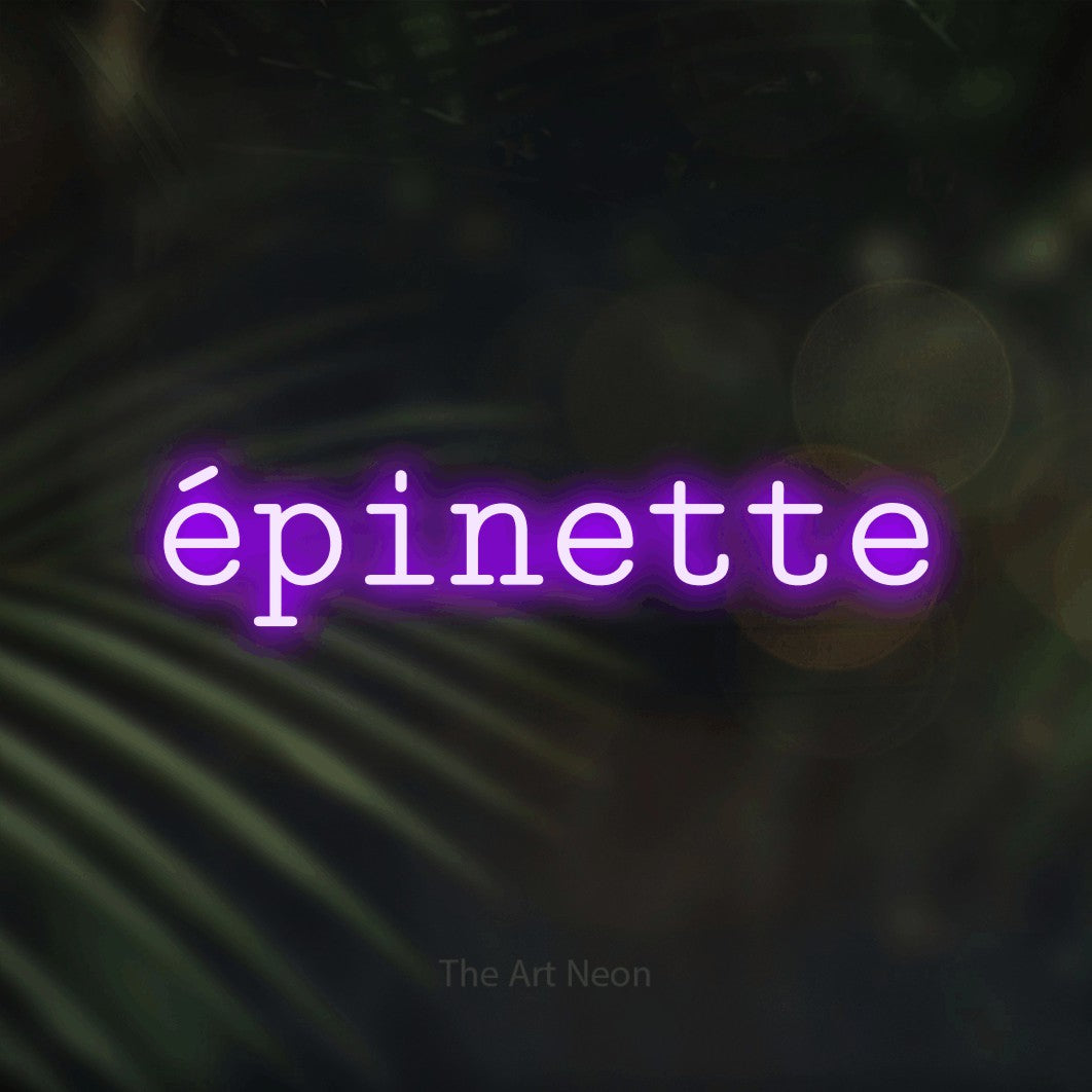 “Épinette” LED neon sign in purple, with typewriter-style lettering, shown against a blurred palm and bokeh-light backdrop.