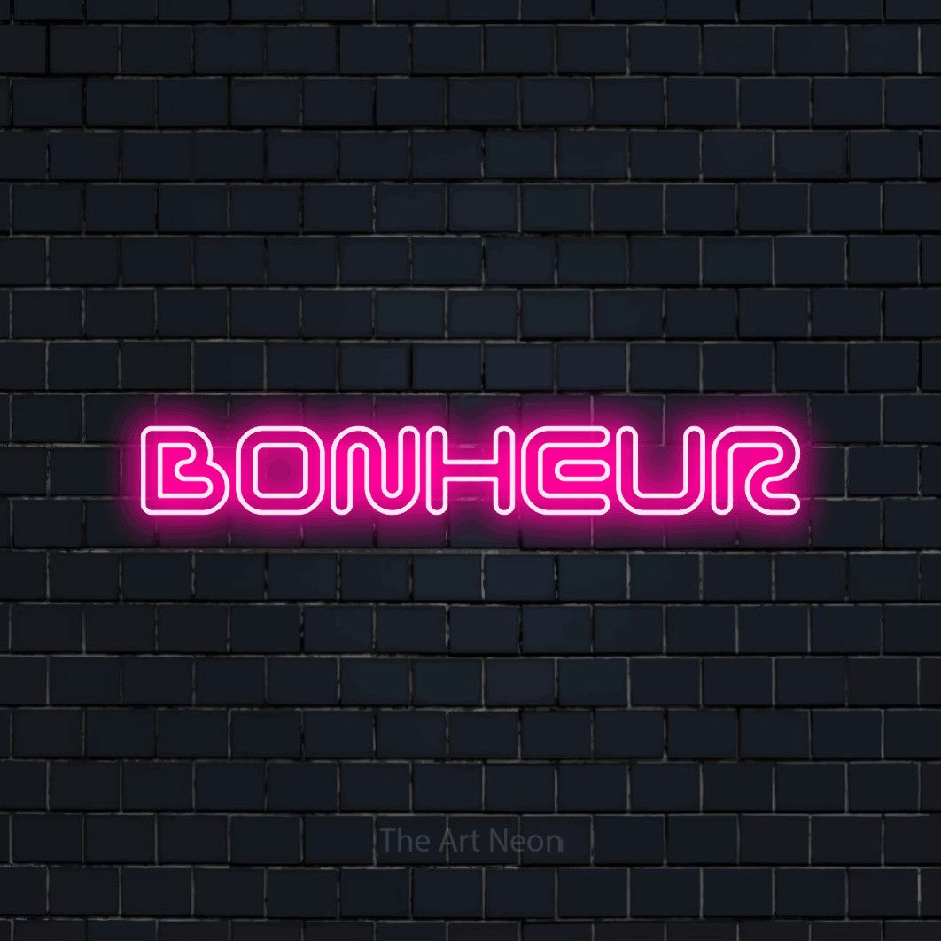 “Bonheur” LED neon sign in hot pink, with futuristic double-line lettering, shown against a dark navy brick wall.