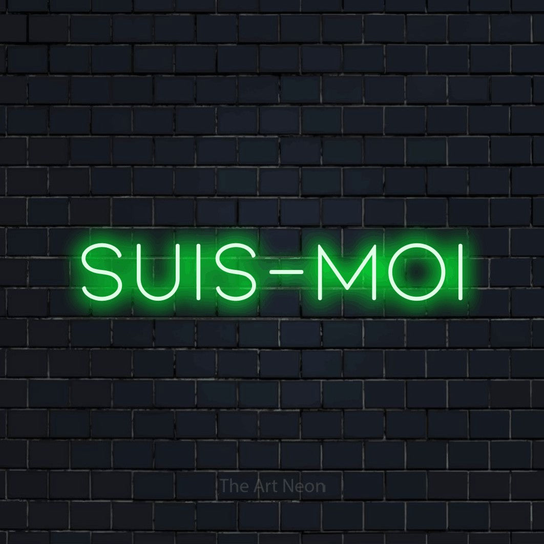 “Suis-moi” LED neon sign in green, with thin, widely spaced lettering, shown against a dark navy brick wall.
