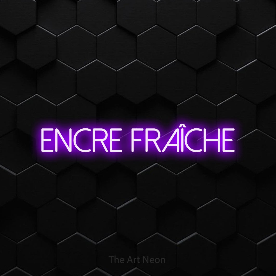 “Encre fraîche” LED neon sign in purple, with thin sans-serif lettering, shown against black hexagonal wall tiles.