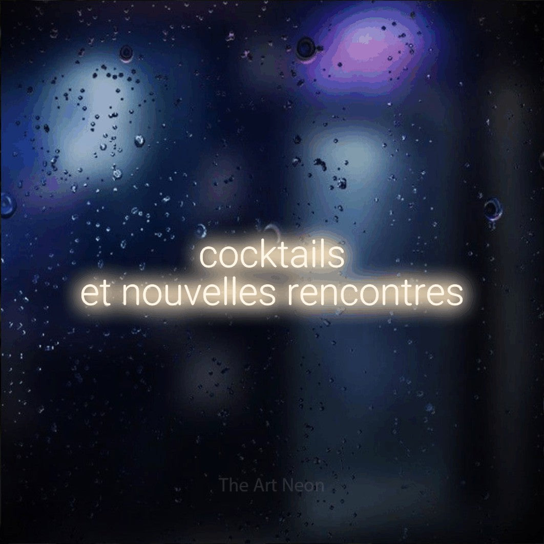 Aperçu d’une enseigne néon LED « Cocktails et nouvelles rencontres » sur deux lignes en blanc chaud, en lettres sans empattement arrondies, photographiée sur une vitre aux reflets bleus et violets, pour un bar ou un pub.