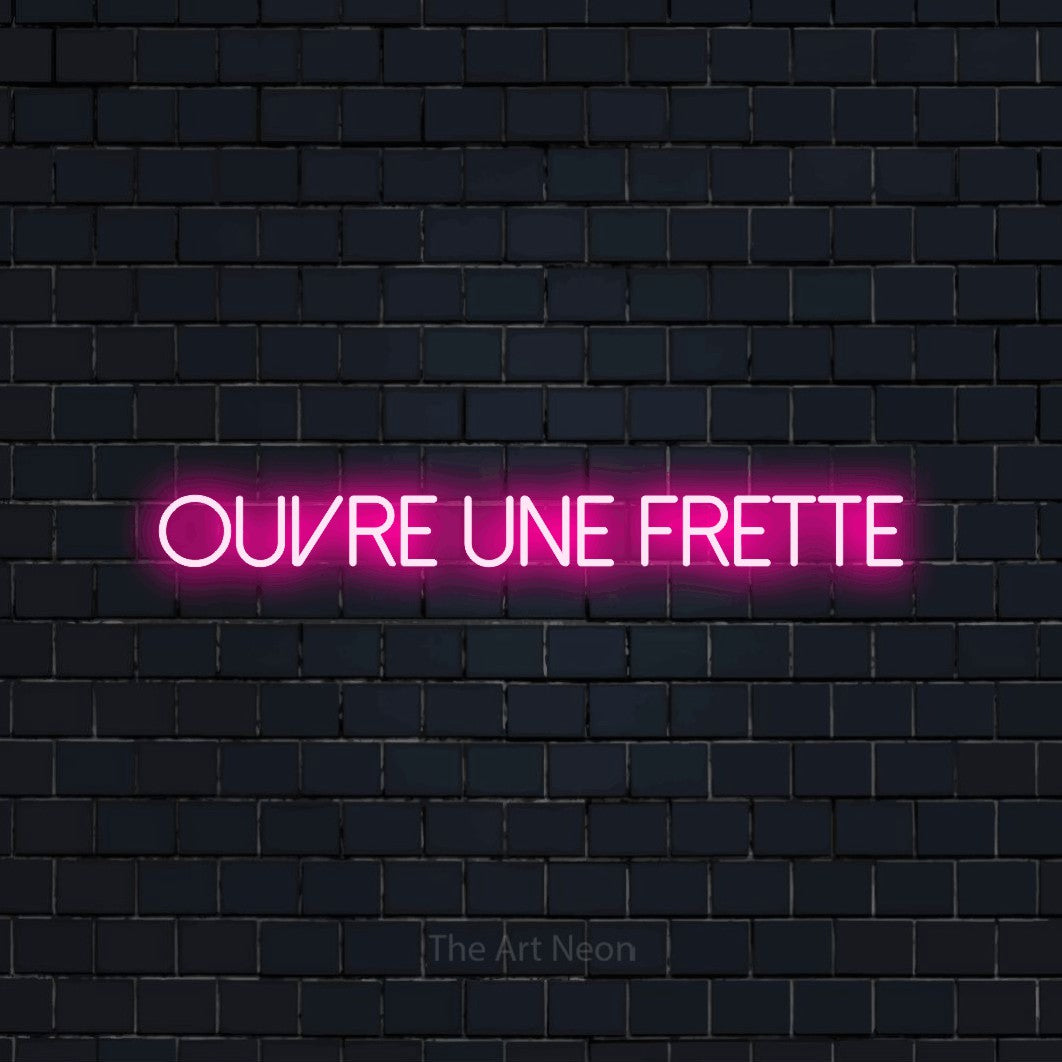 “Ouvre une frette” LED neon sign in hot pink, with thin sans-serif lettering, shown against a dark navy brick wall.