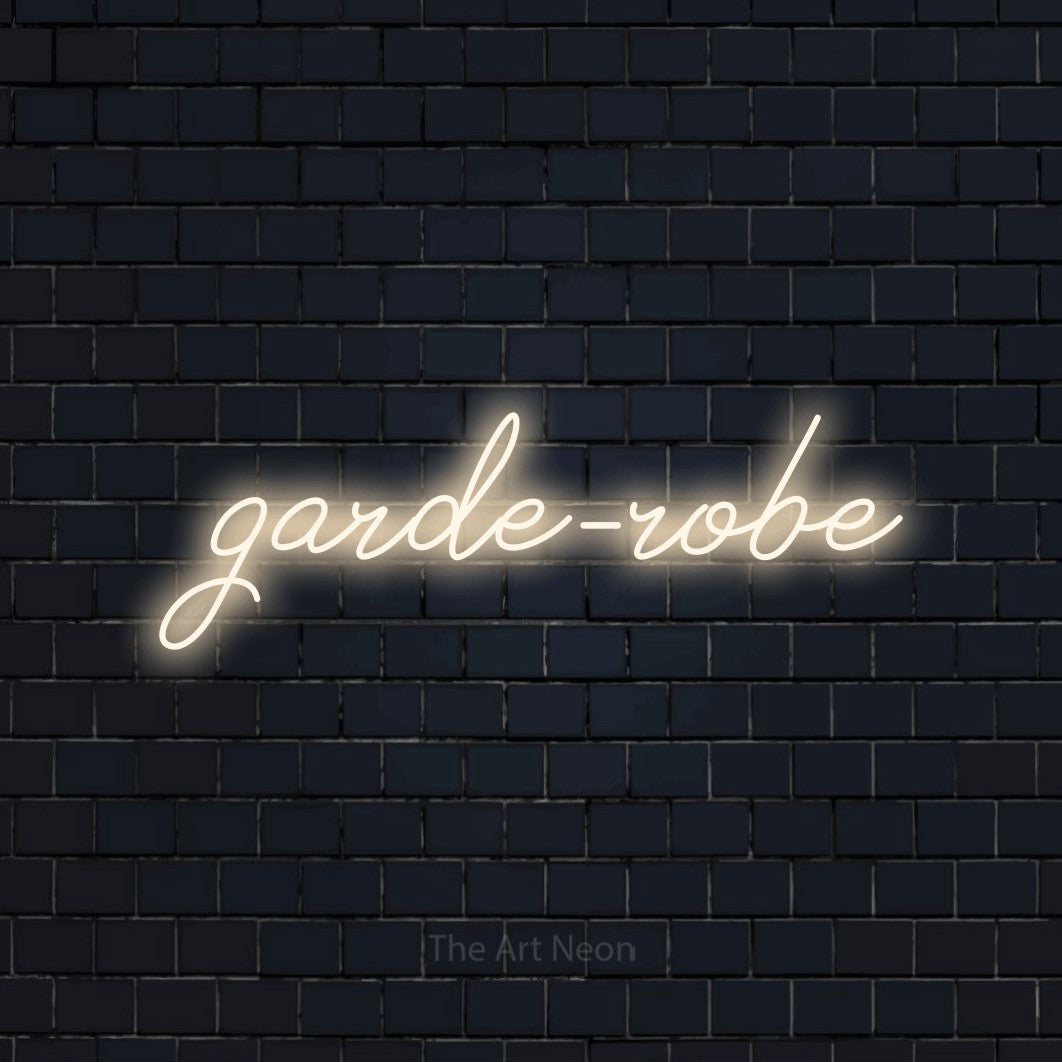 “Garde-robe” LED neon sign in warm white, with cursive lettering, shown against a dark navy brick wall.
