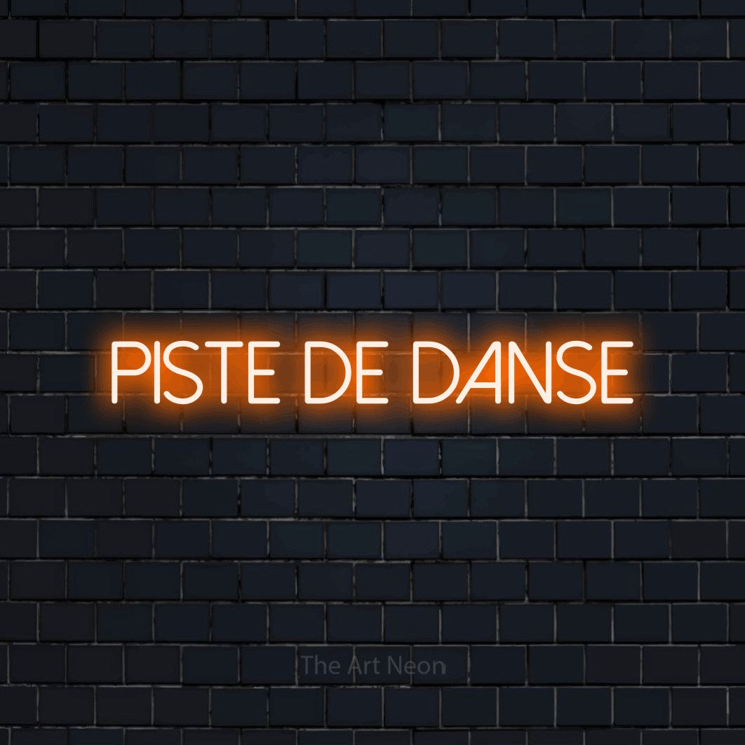 Décoration murale en néon LED « Piste de danse » en orange, en lettres fines sans empattement, installée sur un mur de briques bleu marine foncé, pour une fête.