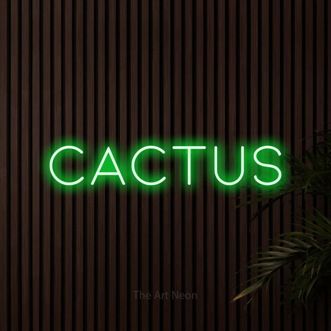“Cactus” LED neon sign in green, with thin, widely spaced lettering, shown against dark wooden wall slats.