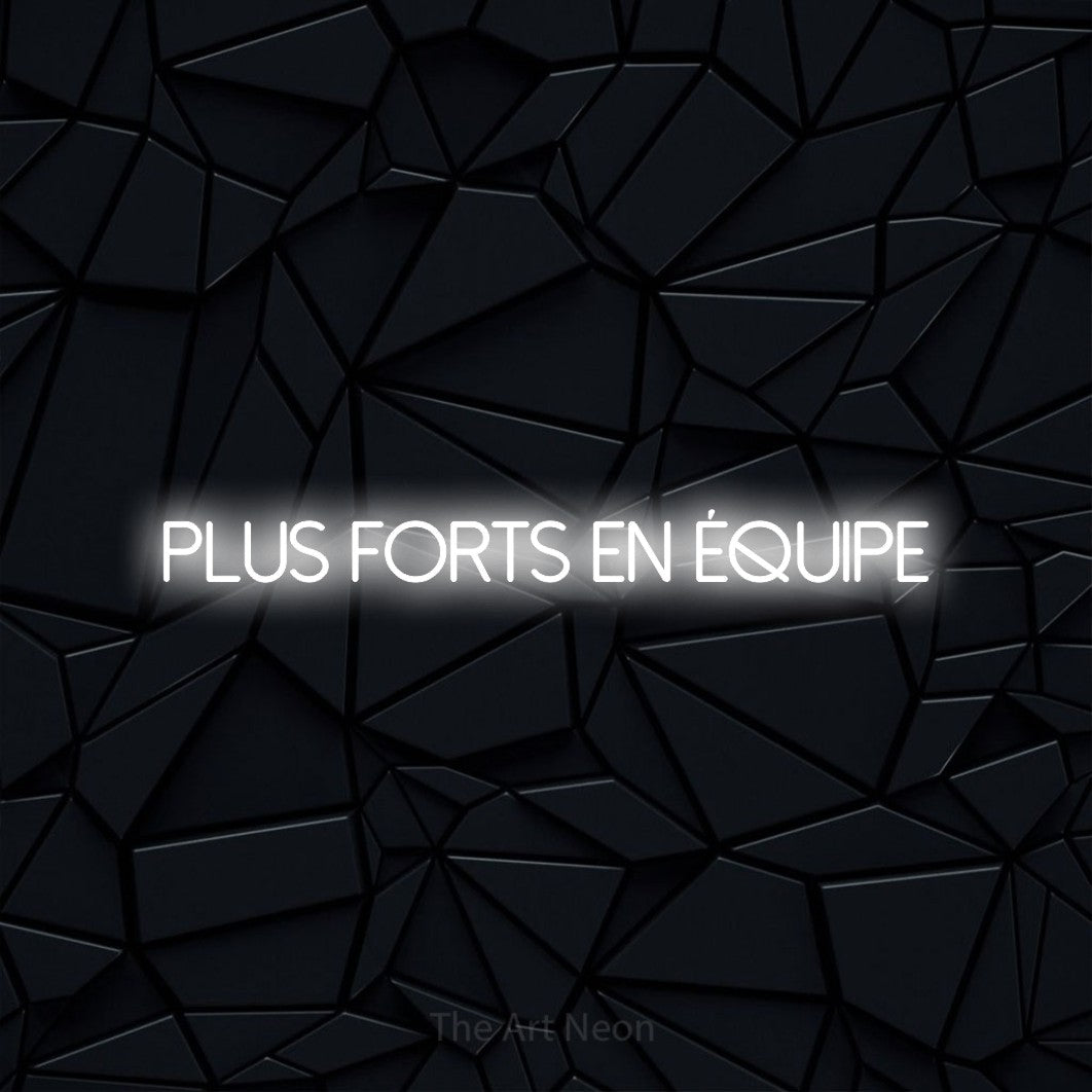 “Plus forts en équipe” LED neon sign in cool white, with thin sans-serif lettering, shown against a black polygonal surface.