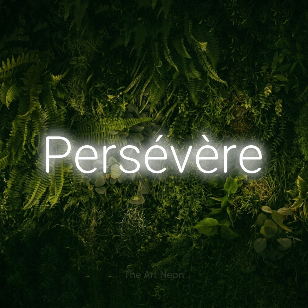 “Persévère” LED neon sign in cool white, with rounded sans-serif lettering, shown against a dark moss and forest backdrop.