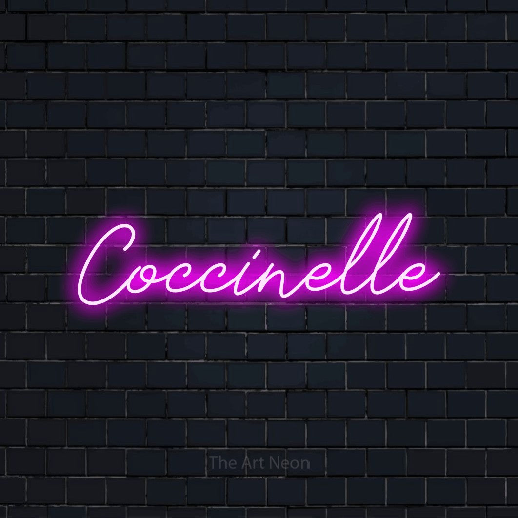 “Coccinelle” LED neon sign in pink, with cursive lettering, shown against a dark navy brick wall.