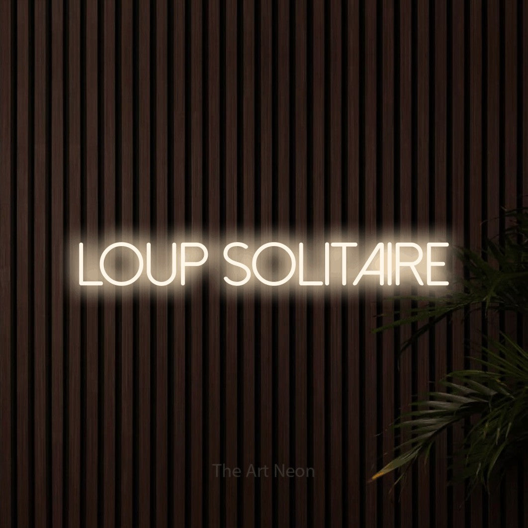 Lettrage en néon LED « Loup solitaire » en blanc chaud, en lettres fines sans empattement, présenté sur un mur de lattes en bois foncé, pour un décor inspiré de la nature.