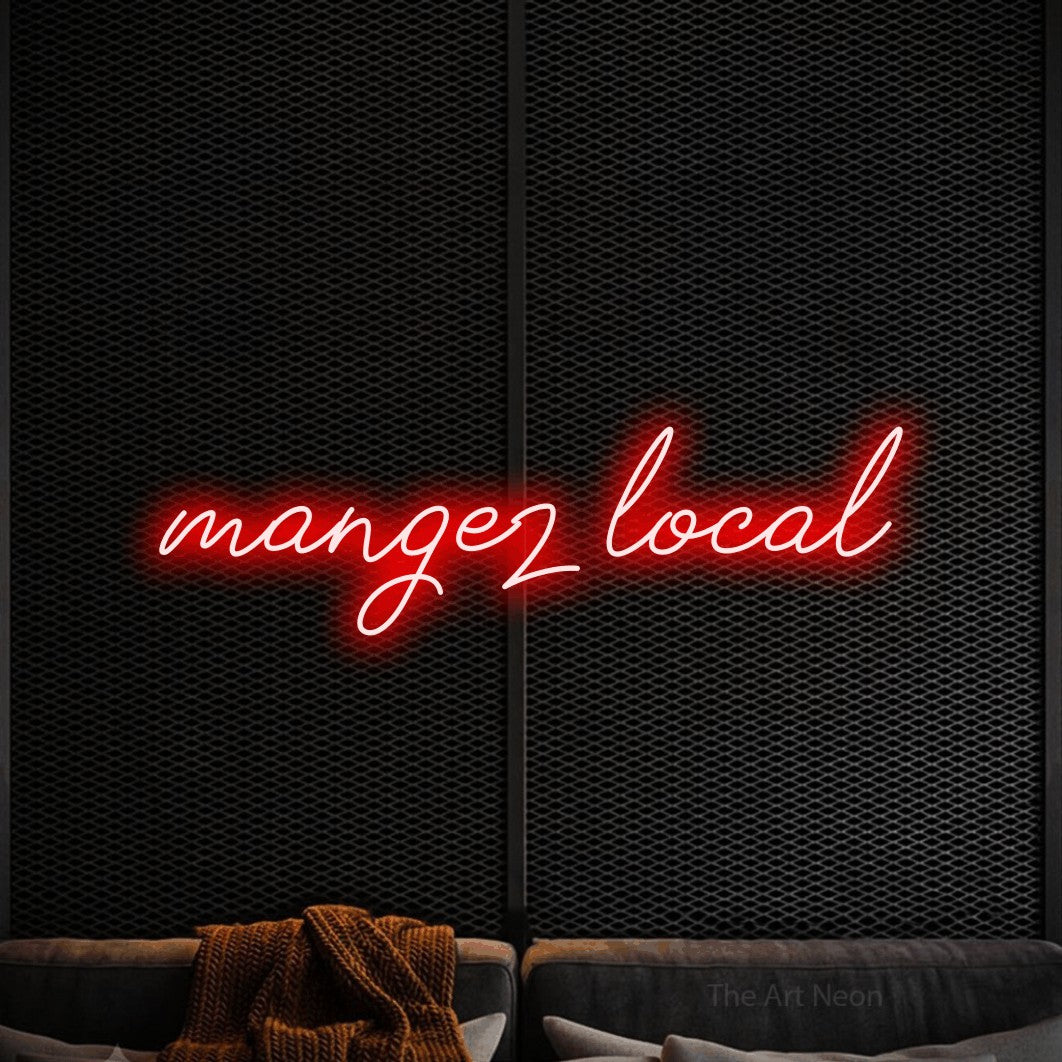 “Mangez local” LED neon sign in red, with cursive lettering, shown against a modern dark-toned seating area.