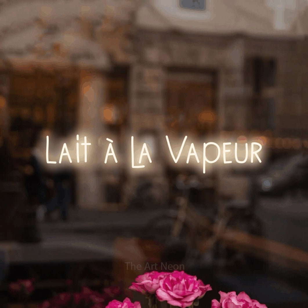 Néon LED « Lait à la vapeur » en blanc chaud, en lettres étroites dessinées à la main, mis en scène dans un décor flou de café-bar, pour un café.