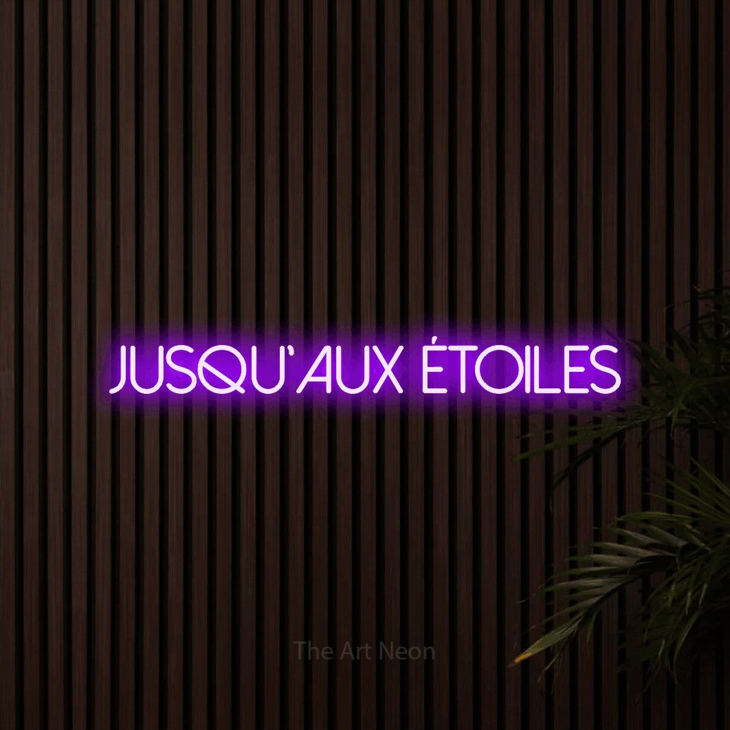 “Jusqu'aux étoiles” LED neon sign in purple, with thin sans-serif lettering, shown against dark wooden wall slats.