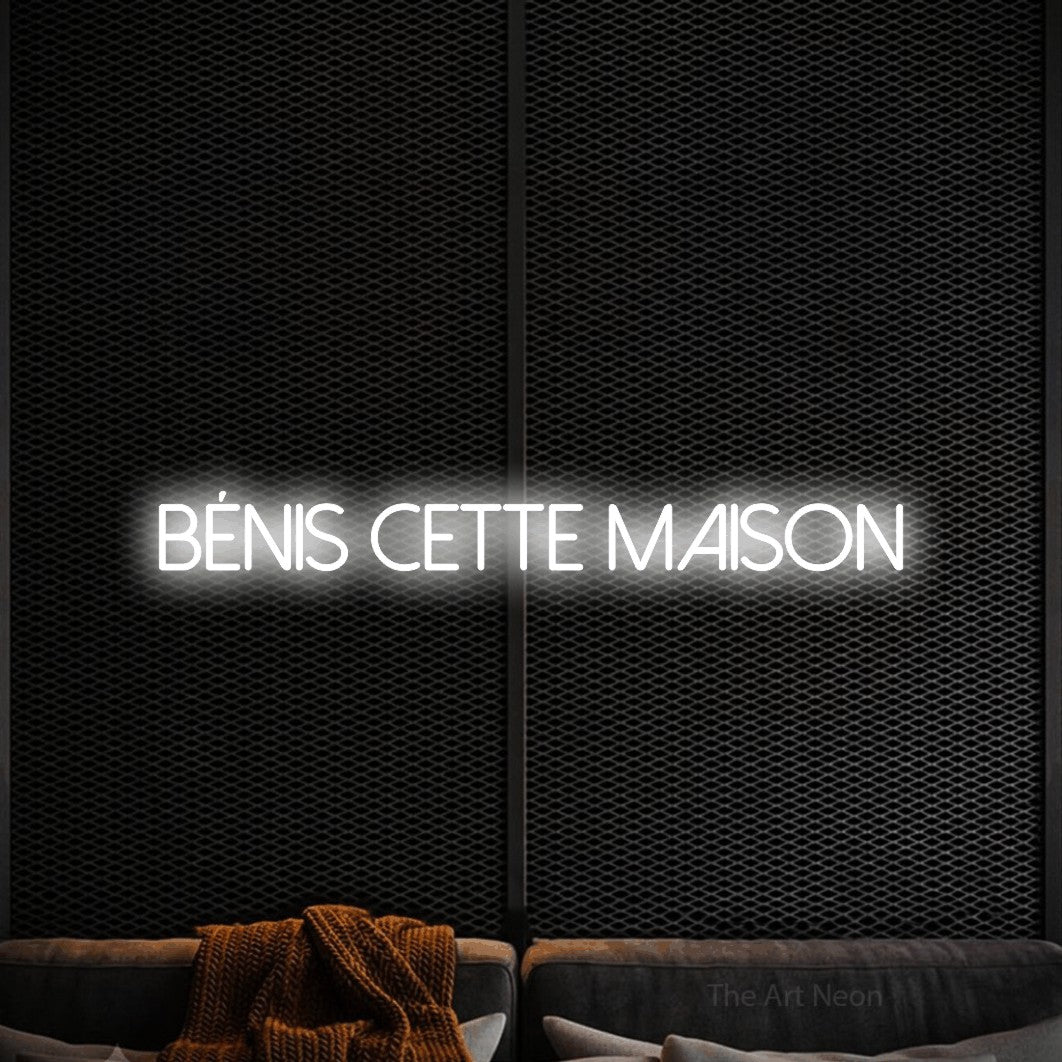 Décoration murale en néon LED « Bénis cette maison » en blanc froid, en lettres fines sans empattement, installée dans un coin salon moderne aux tons noirs, pour un salon.
