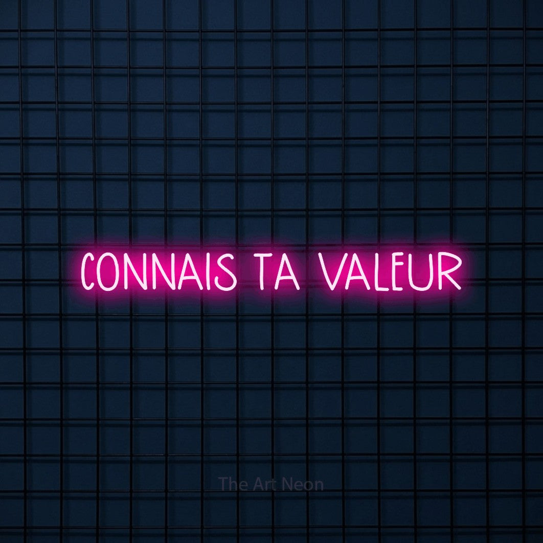 “Connais ta valeur” LED neon sign in hot pink, with narrow hand-drawn lettering, shown against a dark blue grid.