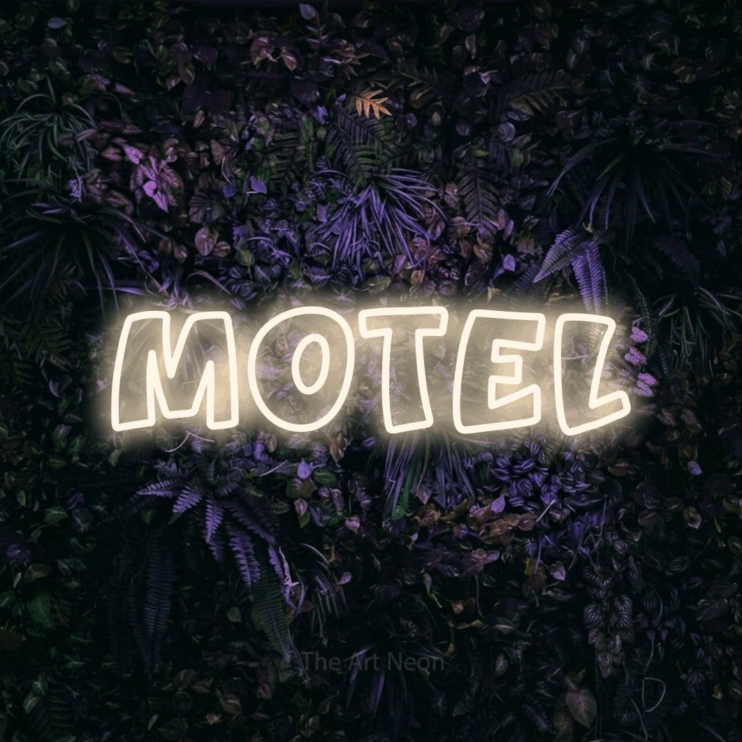 “Motel” LED neon sign in warm white, with rounded outline lettering, shown against a dark wall with purple flowers.