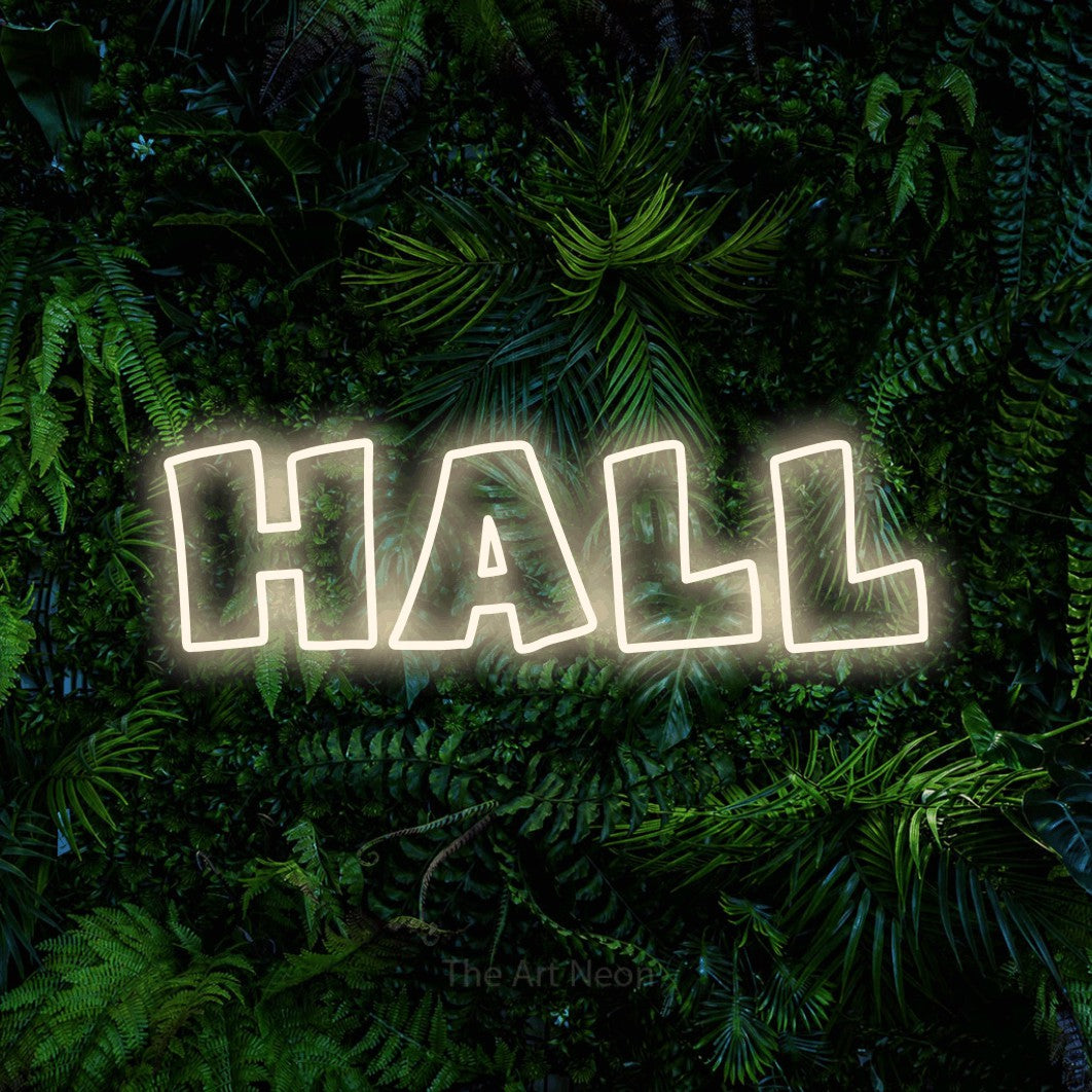 “Hall” LED neon sign in warm white, with wide lettering with irregular outlines, shown against dense tropical foliage.