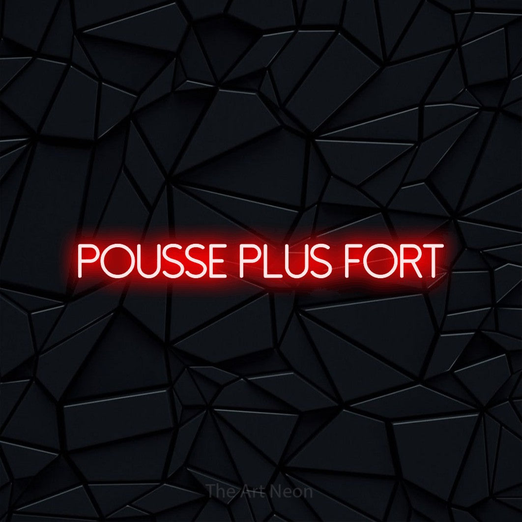 Composition en néon LED « Pousse plus fort » en rouge, en lettres fines sans empattement, mise en valeur sur une surface polygonale noire, pour un espace d’entraînement.