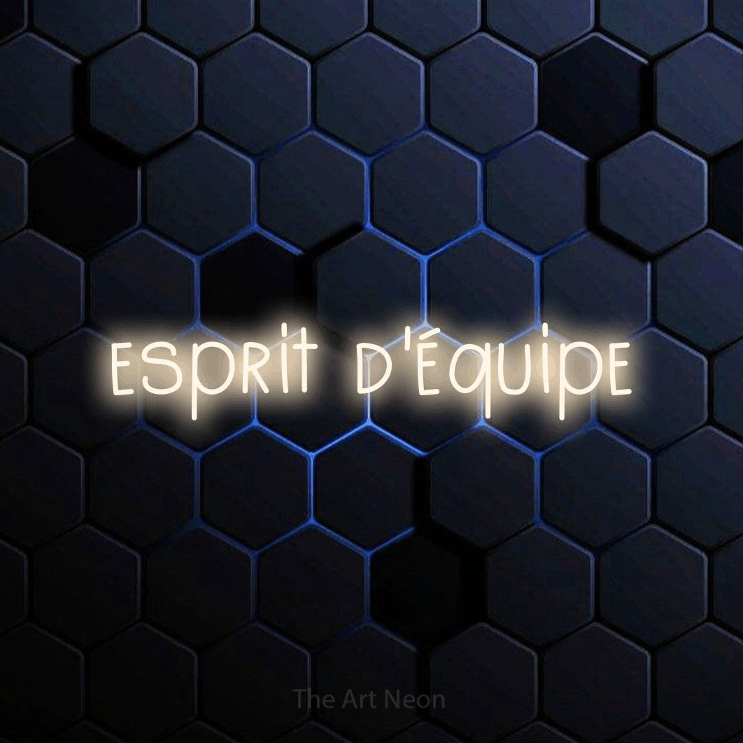 “Esprit d'équipe” LED neon sign in warm white, with narrow hand-drawn lettering, shown against a dark blue honeycomb pattern.