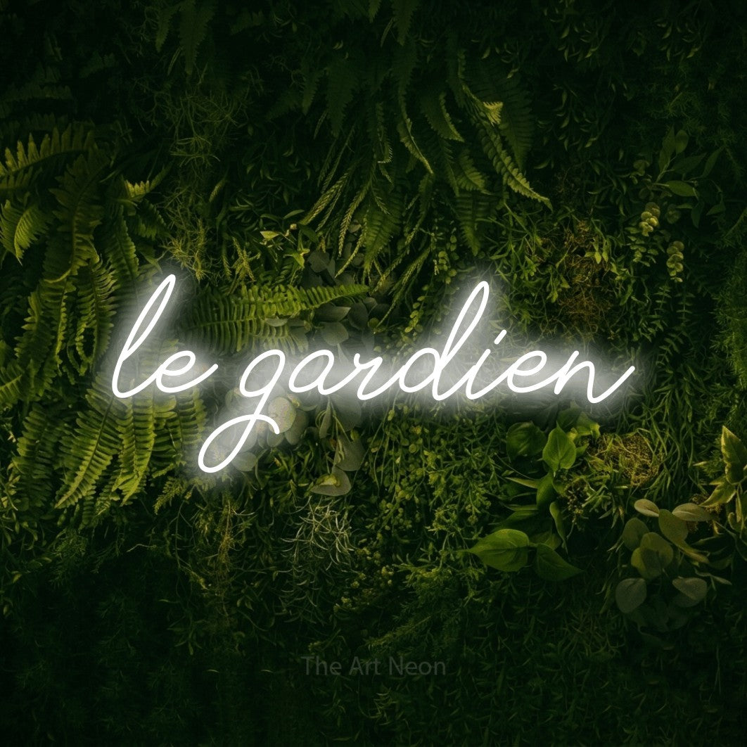 Néon LED « Le gardien » en blanc froid, en lettrage cursif, mis en scène sur un fond sombre de mousse et de forêt, pour un décor de hockey.