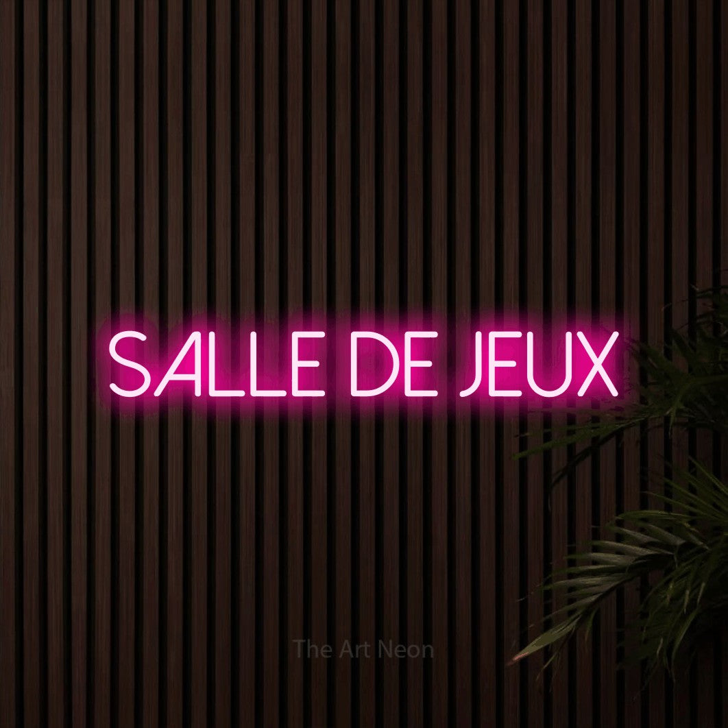 “Salle de jeux” LED neon sign in hot pink, with thin sans-serif lettering, shown against dark wooden wall slats.