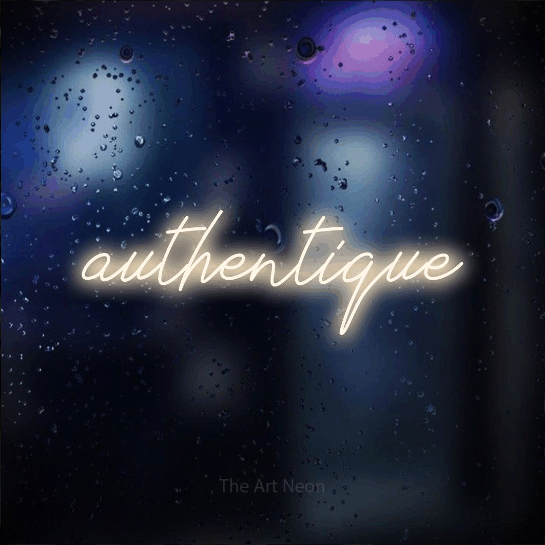 “Authentique” LED neon sign in warm white, with cursive lettering, shown against glass with blue and purple reflections.