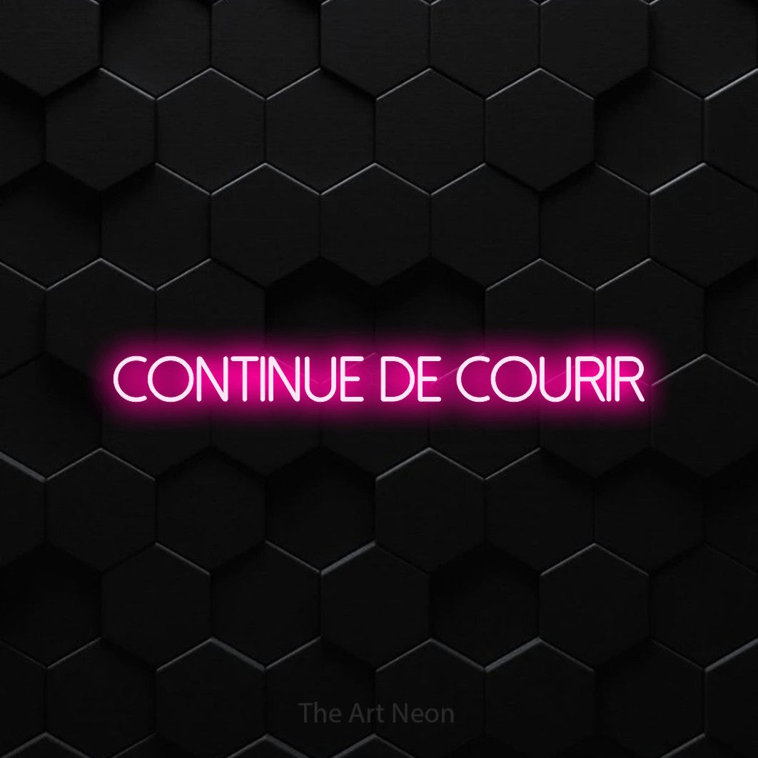 “Continue de courir” LED neon sign in hot pink, with thin sans-serif lettering, shown against black hexagonal wall tiles.