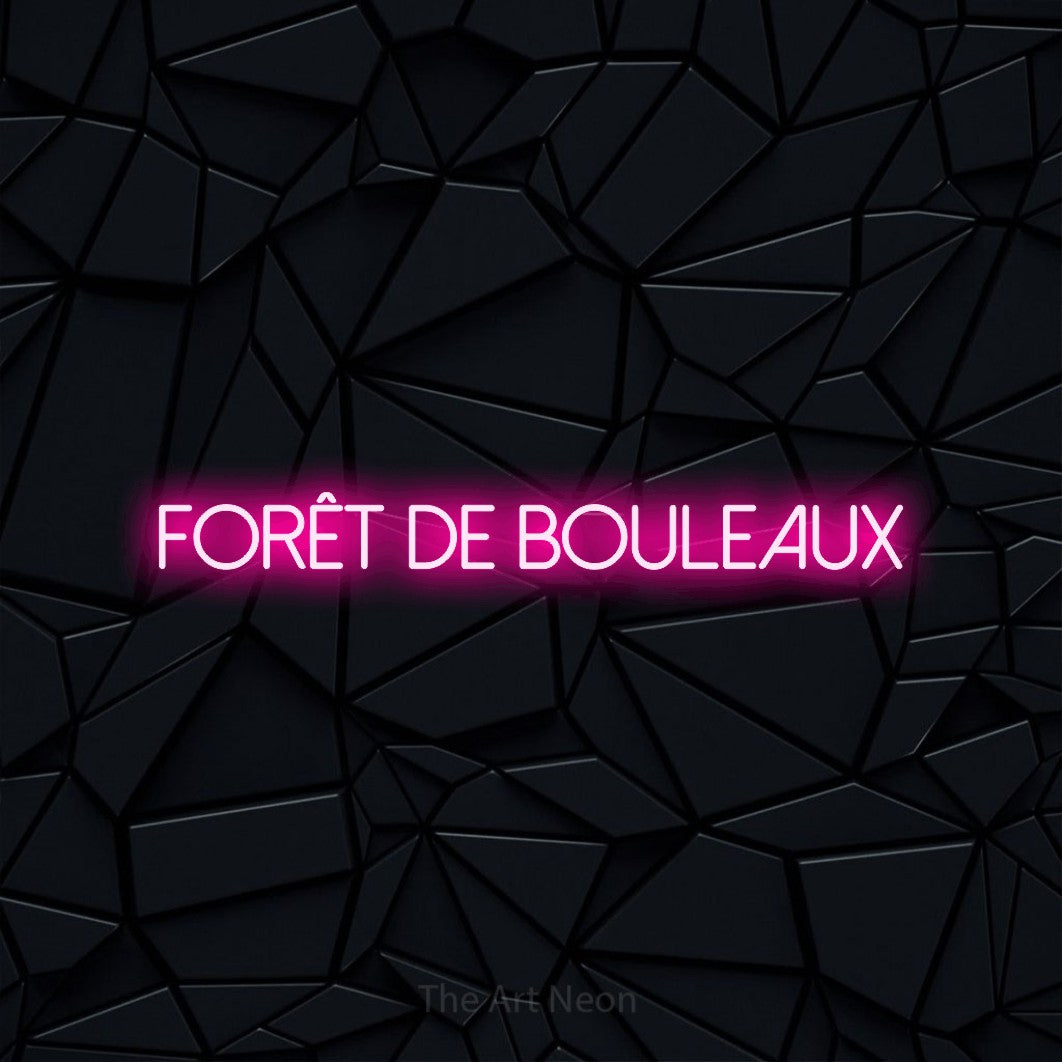 “Forêt de bouleaux” LED neon sign in hot pink, with thin sans-serif lettering, shown against a black polygonal surface.