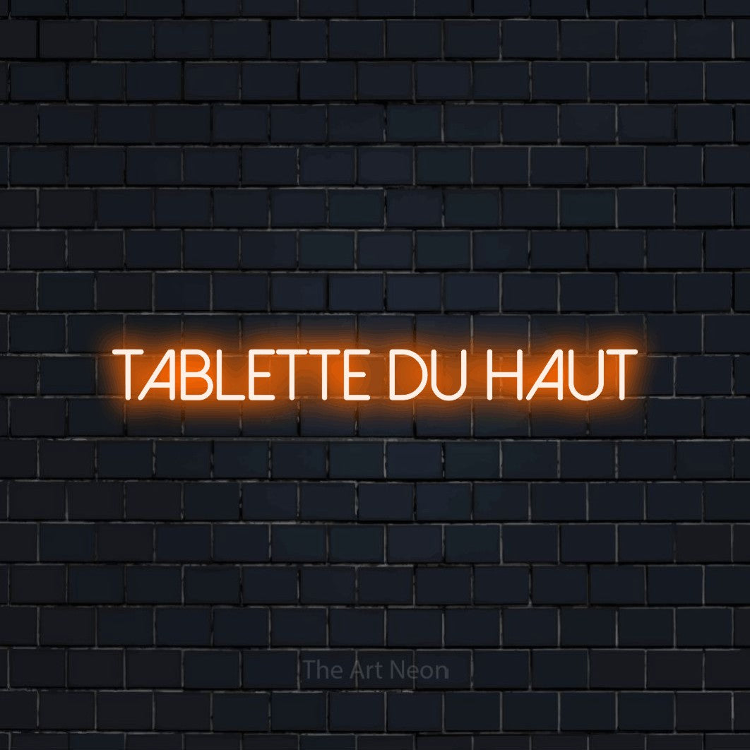 Aperçu d’une enseigne néon LED « Tablette du haut » en orange, en lettres fines sans empattement, photographiée sur un mur de briques bleu marine foncé, pour un bar à la maison.