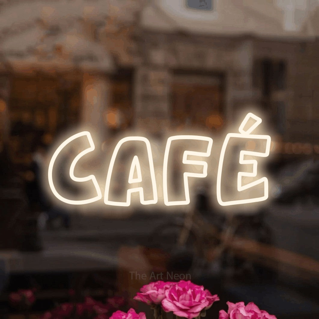 “Café” LED neon sign in warm white, with rounded outline lettering, shown against a blurred café-bar interior.